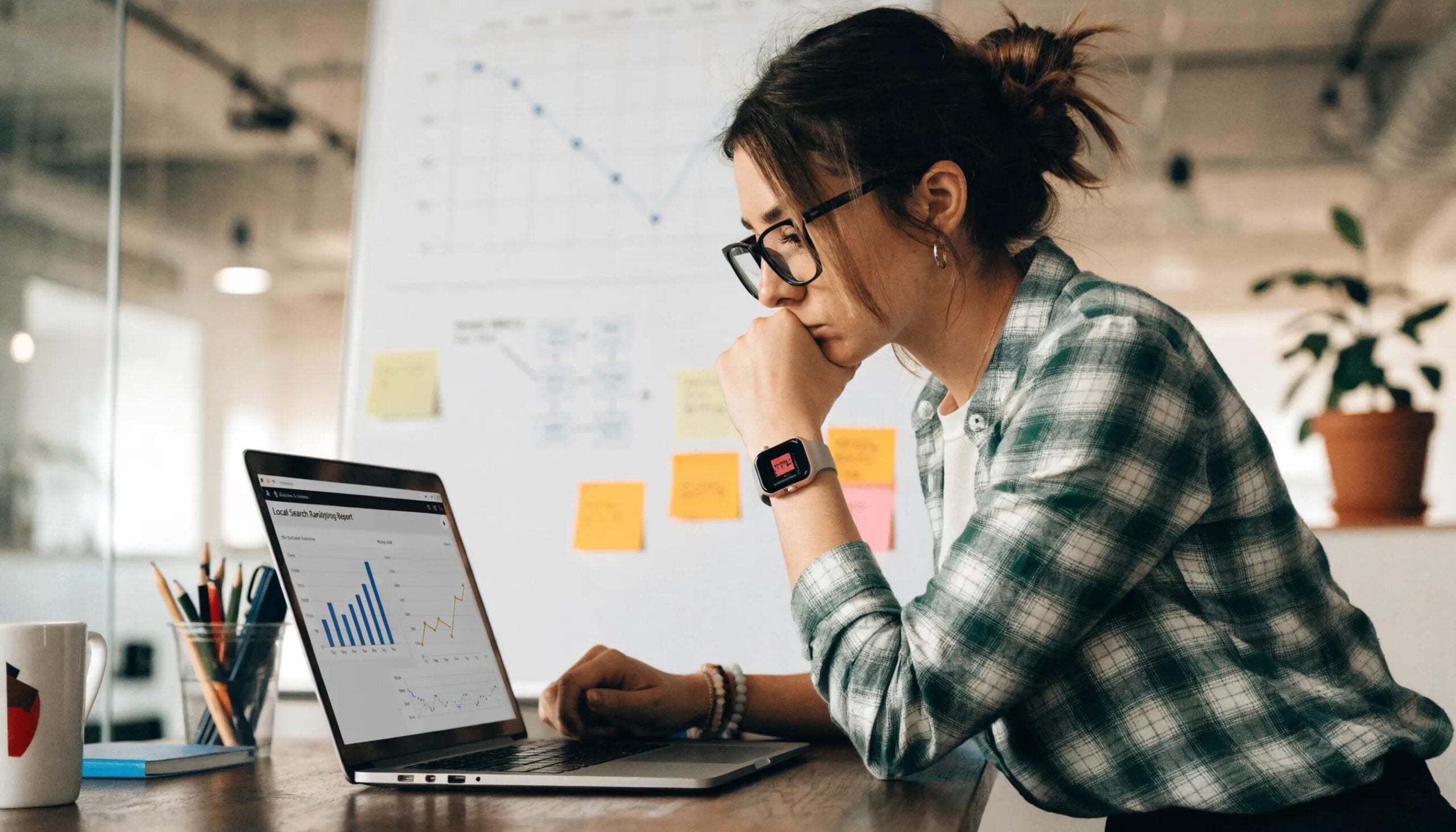 Business owner reviewing local search ranking data on a laptop, representing strategies for enhancing GBP and SEO effectiveness